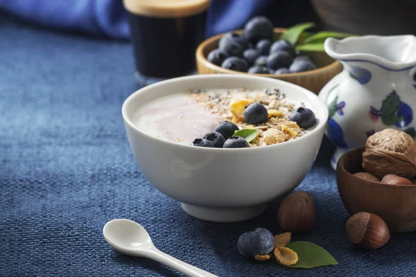 Yoğurt, kahve ve koyu mavi peçete üzerinde çeşitli tahıl taze yaban mersini ile sağlıklı klasik kahvaltı. Metin alanı.