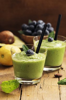 Smoothie tarifi yeşil ıspanak, ahşap tahta üzerinde badem ile. İyi olmak ve kilo kaybı kavramı.