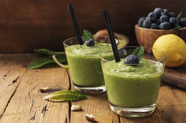Smoothie tarifi yeşil ıspanak, ahşap tahta üzerinde badem ile. İyi olmak ve kilo kaybı kavramı.