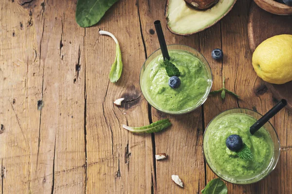 Smoothie tarifi yeşil ıspanak, ahşap tahta üzerinde badem ile. İyi olmak ve kilo kaybı kavramı.