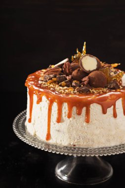 Pekan fındık çikolata truffles siyah arka plan üzerine karamel çizgileri ile şenlikli pastayla