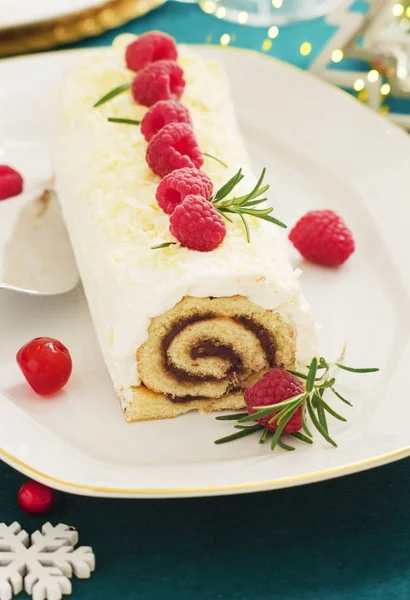 White chocolate cream yule log Christmas cake with  raspberries.