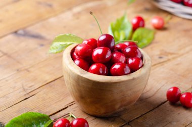 Rustik masada ahşap kase taze olgun kiraz.