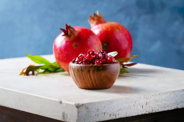 Semillas Granada Tazón Madera Vivo Con Frutas Hojas Una Mesa —  Fotos de Stock