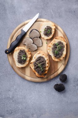 Gri masa üzerinde siyah trüf bruschetta.