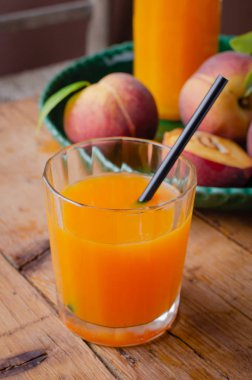 Ahşap masada kahvaltı için cam taze ev yapımı şeftali suyu . Rustik stile. Boş metin alanı.