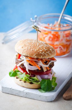 Mermer masa üzerinde ahşap üzerine fermente gıdalar kimchi, barbekü sığır pirzonu ile Burger.
