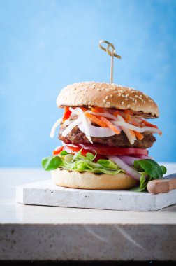 Mermer masa üzerinde ahşap üzerine fermente gıdalar kimchi, barbekü sığır pirzonu ile Burger.