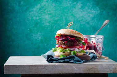 Fermente lahana ile Burger, pancar daldırma, mermer masa üzerinde ahşap barbekü sığır pirzonu.
