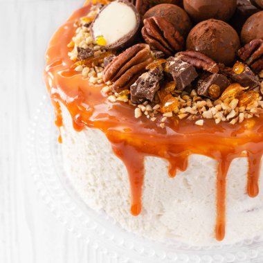 Beyaz arka plan üzerinde karamel çizgileri ile pekan fındık çikolata truffles ile Şenlikli kek