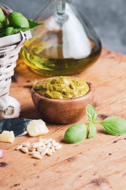 Rustik masa üzerinde çam fıstığı, fesleğen, parmesan ve sarımsak ile zeytin ahşap kase pesto sos.