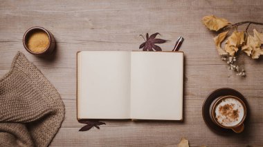 Kırmızı kalem, sonbahar yaprakları, cappuccino ve rahat yün eşarp ile sonbahar mockup eski defter. Düz yatıyordu, üst görünüm.