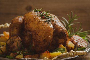 Şenlikli metal plaka üzerinde kavrulmuş tavuk ve patates, ıspanak, Garlik ve biberiye.