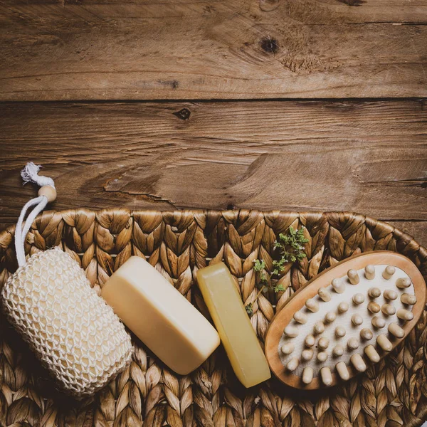 Ahşap arka planda sabun ve doğal masaj bezi kiti.