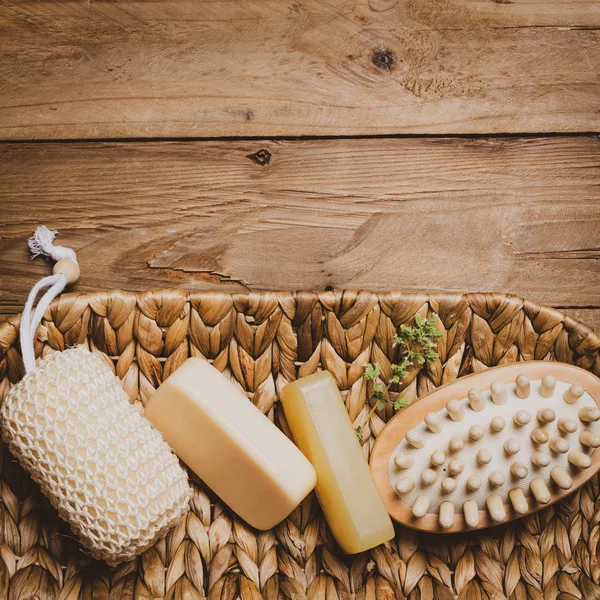 Ahşap arka planda sabun ve doğal masaj bezi kiti.