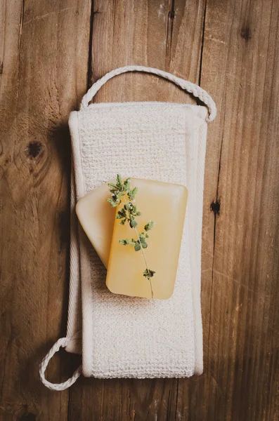 Ahşap arka planda ot ile sabun ile bez.