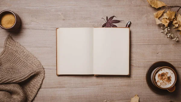 Kırmızı kalem, sonbahar yaprakları, cappuccino ve rahat yün eşarp ile sonbahar mockup eski defter. Düz yatıyordu, üst görünüm.