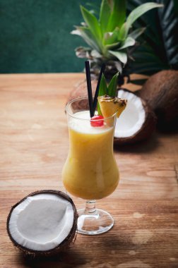 Tropikal Karayip kokteyl Pina Colada Hindistan cevizi ve ananas ile ahşap masa üzerinde bir gözlük.