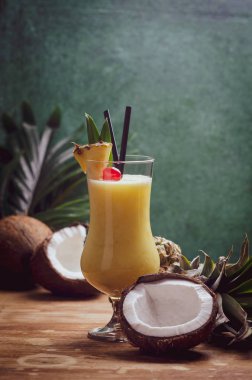 Tropikal Karayip kokteyl Pina Colada Hindistan cevizi ve ananas ile ahşap masa üzerinde bir gözlük.