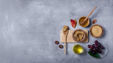 Esmer şekeri üzüm ve yağla ovmak için gerekli malzemeler, cilt bakımı için çevre dostu kozmetik ürünler..