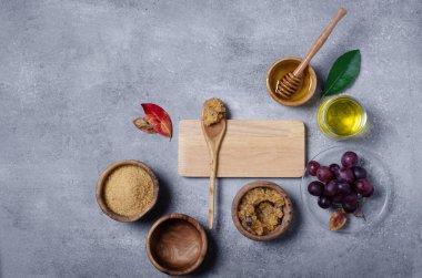 Esmer şekeri üzüm ve yağla ovmak için gerekli malzemeler, cilt bakımı için çevre dostu kozmetik ürünler..
