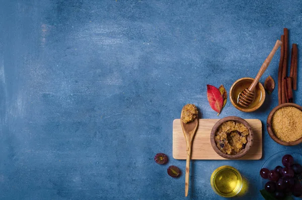 Esmer şekeri üzüm ve yağla ovmak için gerekli malzemeler, cilt bakımı için çevre dostu kozmetik ürünler..