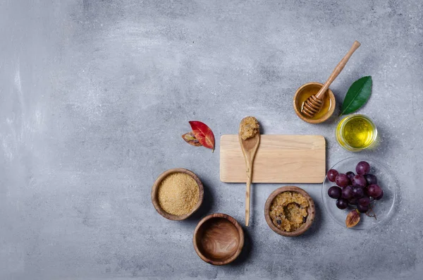 Esmer şekeri üzüm ve yağla ovmak için gerekli malzemeler, cilt bakımı için çevre dostu kozmetik ürünler..