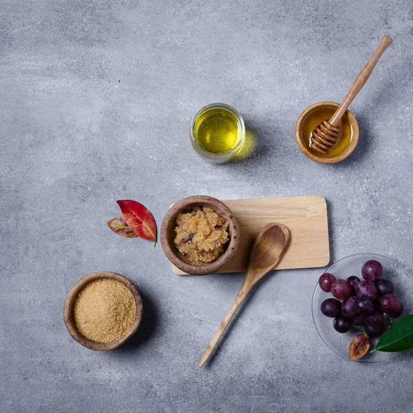 Esmer şekeri üzüm ve yağla ovmak için gerekli malzemeler, cilt bakımı için çevre dostu kozmetik ürünler..