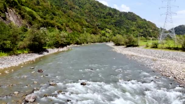 Vol de retour aérien au-dessus de la rivière de montagne au-delà de ses rapides. Pris par drone — Video