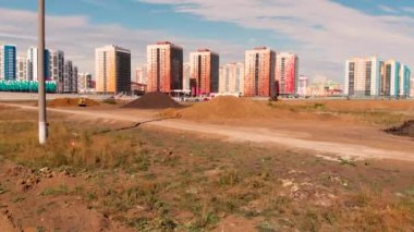 Bir yol inşa etmek için zemini dümdüz eden buldozerin yanından uçarak geçmek
