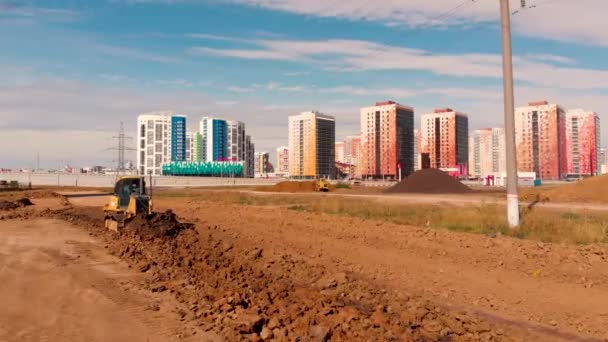 道路を建設するために地面を平らにする作業用ブルドーザーを通過する飛行 — ストック動画