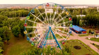 Küçük bir lunaparkın bölgesindeki dönme dolap üzerinde uçan hava yükselmesi.