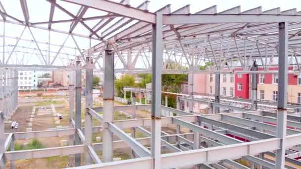 Vol aérien au-dessus des cadres métalliques du bâtiment en construction — Video