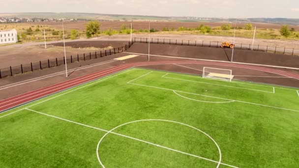 Aerial diagonal flygning tillbaka från den nya fotbollsplan och utomhus idrottsplats — Stockvideo