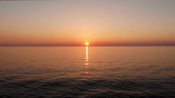 Літаючи над водою вперед до сонця, яке впадає в море. Взято безпілотником під час заходу сонця — стокове відео