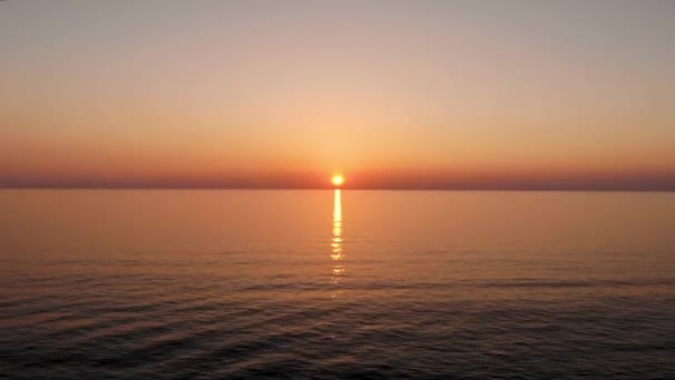 Політ над водою назад від сонця, який відправляється в море. Взято безпілотником під час заходу сонця — стокове відео