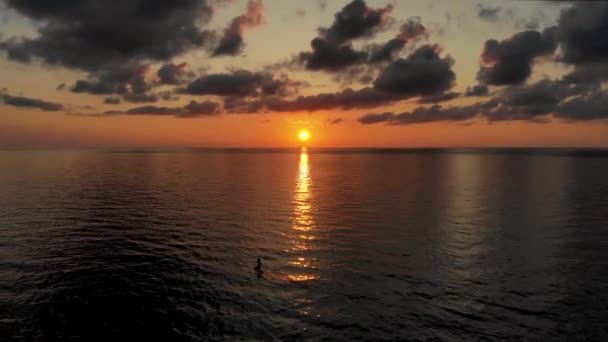 Повітряний політ назад від відьом, що плавають на каяках і дошках СУП на заході сонця — стокове відео