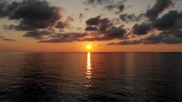 Vuelo sobre el agua hacia un paisaje fascinante: puesta de sol y nubes oscuras — Vídeo de stock