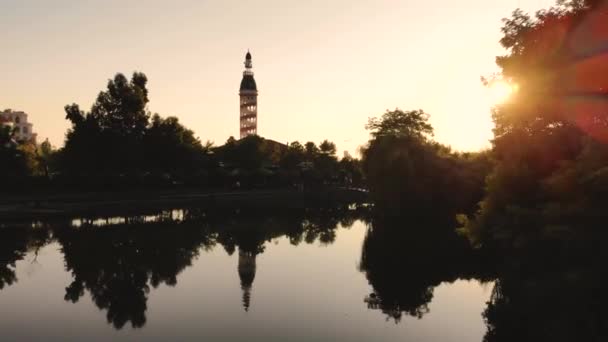 Latające samoloty wznoszą się nad małym jeziorem tuż nad morzem. Zabrany przez drona o zachodzie słońca. — Wideo stockowe