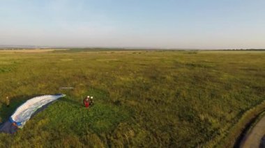 Paraglider gün batımında vinçle yola çıkıyor.