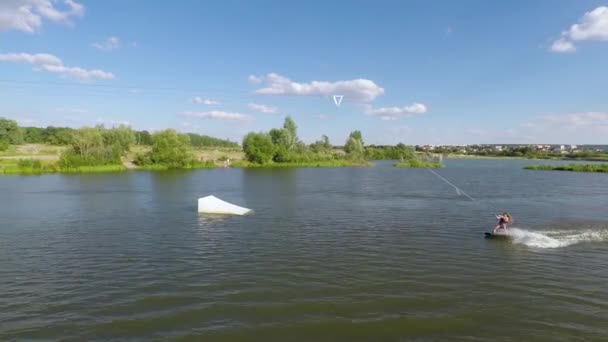 Rapariga rápida monta em um wakeboard. Vista aérea — Vídeo de Stock