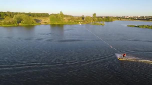 Jovem rápido monta em um wakeboard. Vista aérea — Vídeo de Stock