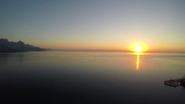 Aerial view of sunrise from the sea. Aerial slow flight right. — Stock Video