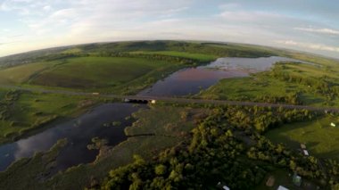 Gün batımında göl ve köprü üzerinde uçan hava.