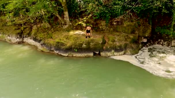 Légi felvétel fiatal fickókról, akik a hegyi erdei tóban ugrálnak. A drón elrabolta. — Stock videók
