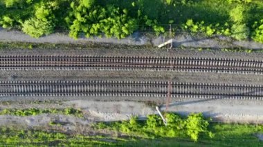 Elektrik hatları olan boş bir demiryolu üzerinde havadan uçuş. Gün batımında insansız hava aracı tarafından çekiliyor.