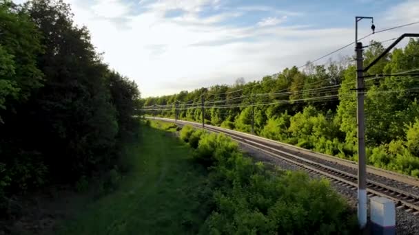 Vuelo aéreo sobre un ferrocarril vacío con líneas eléctricas. Tomado por dron al atardecer — Vídeo de stock