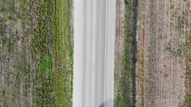 Vuelo aéreo sobre una carretera por la que pasan los coches. Tomado por un dron, mirando hacia abajo — Vídeos de Stock