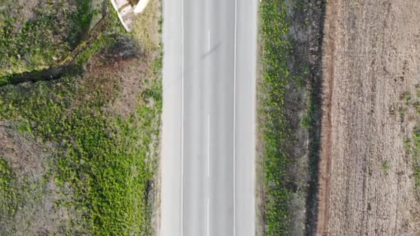 Vuelo aéreo sobre una carretera de dos carriles a lo largo de la cual pasan los coches. Tomado por dron — Vídeo de stock