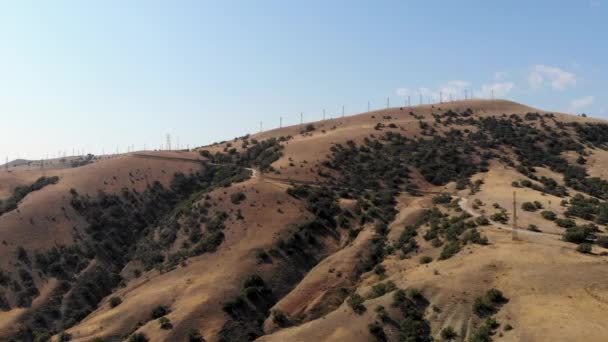 Воздушный полет на ветряные мельницы, стоящие на вершине горы. Снято беспилотником — стоковое видео